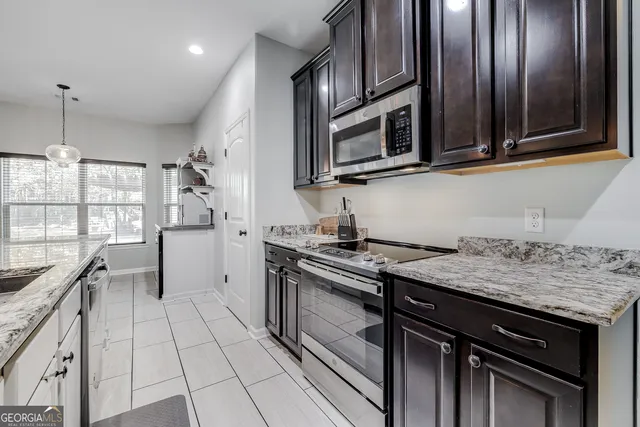 a kitchen with stainless steel appliances granite countertop a stove microwave and sink