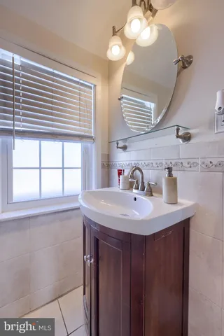 a bathroom with a sink a large mirror and a window