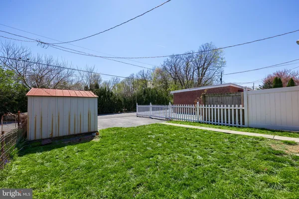 a view of a backyard with a small cabin and wooden fence