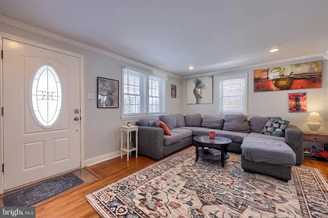 a living room with furniture a rug a lamp and a window