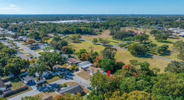 an aerial view of residential houses with outdoor space and trees