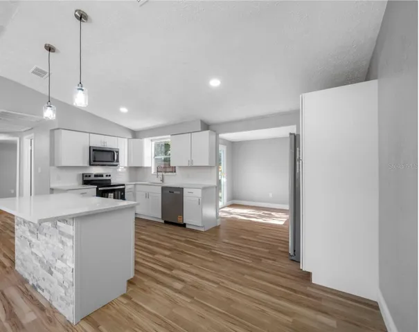 a kitchen with stainless steel appliances granite countertop a sink a stove and a refrigerator