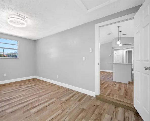 a view of empty room with wooden floor
