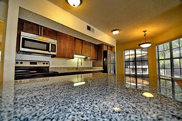 a kitchen with stainless steel appliances a stove a refrigerator and a microwave