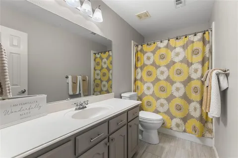 a bathroom with a sink a toilet and a shower curtain