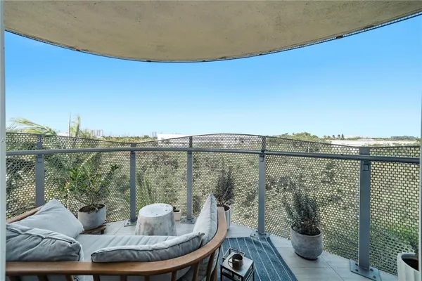 a view of a balcony with furniture and wooden floor