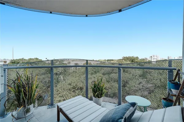 a view of a balcony with chairs and wooden fence