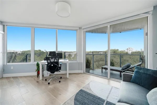 a view of a workspace with furniture and a window