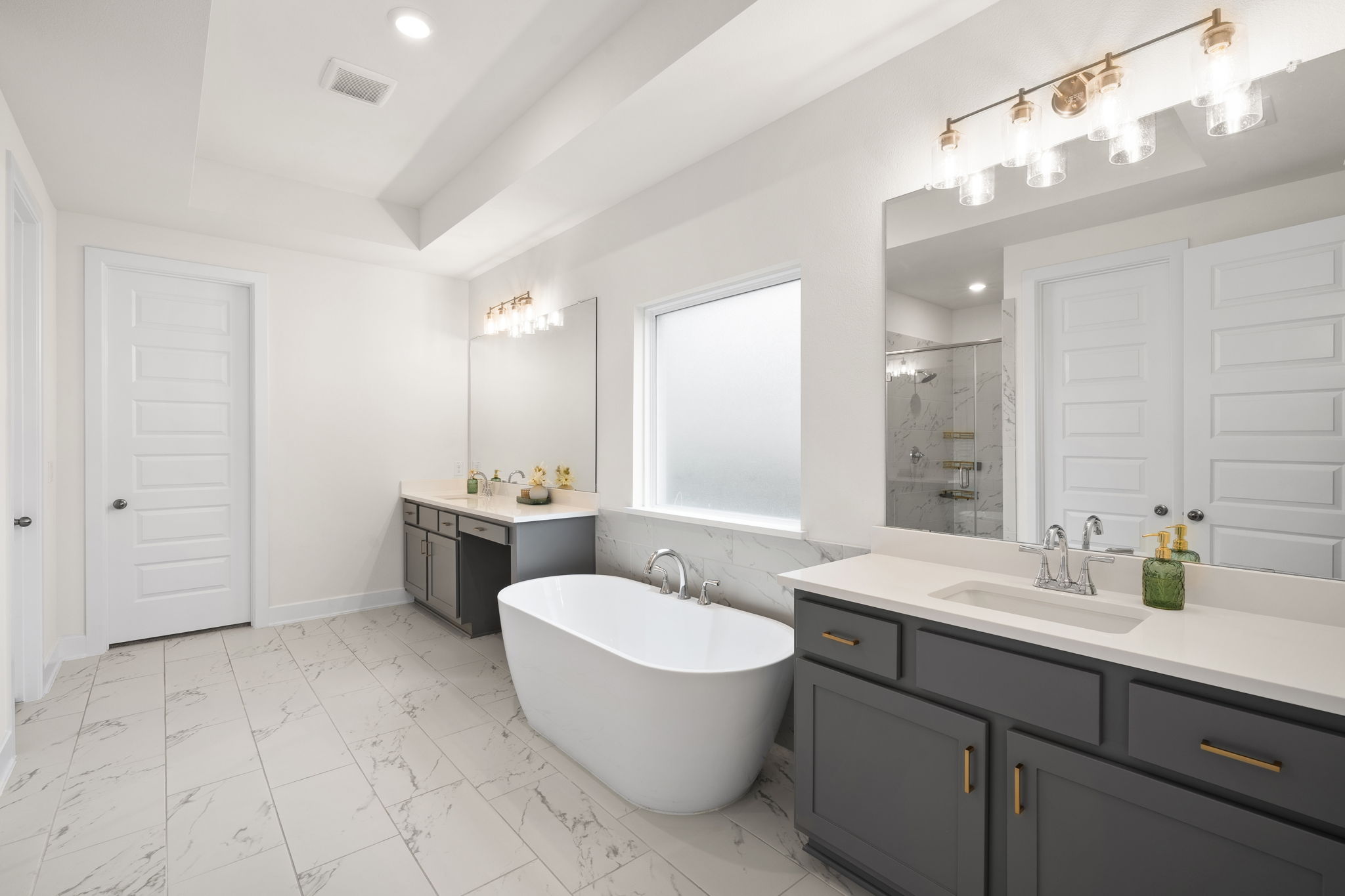 515 Watershield Cove Georgetown, TX 78633 - Photo 19 of 40 Indulge in this contemporary bathroom featuring a freestanding tub, sleek vanities, and a spacious shower.
