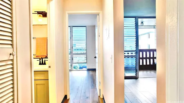 a view of a hallway with wooden floor and windows