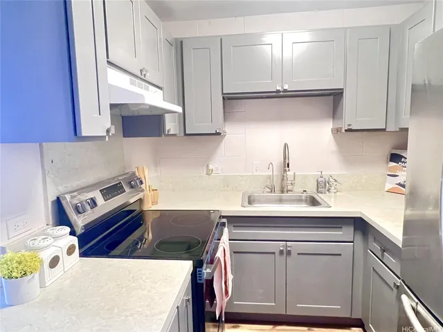 a kitchen with a sink a stove and a refrigerator