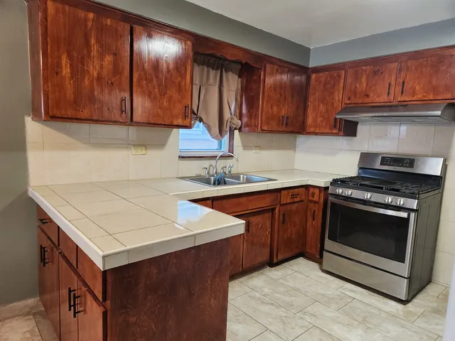 a kitchen with stainless steel appliances granite countertop a stove a sink and a refrigerator