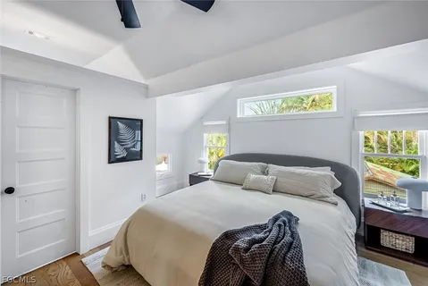 a bedroom with a large bed and a potted plant