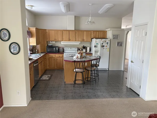 a kitchen with stainless steel appliances a refrigerator a sink a stove and white cabinets