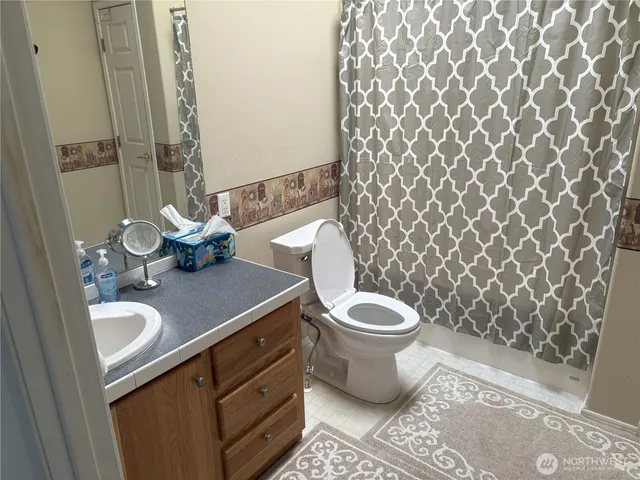 a bathroom with a granite countertop toilet and sink