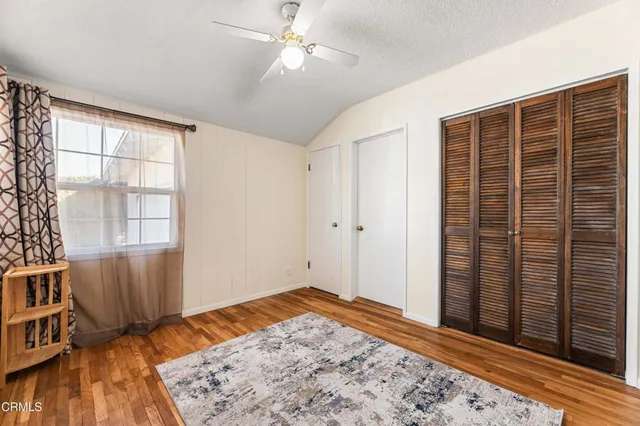 a bedroom with a bed a window and dresser