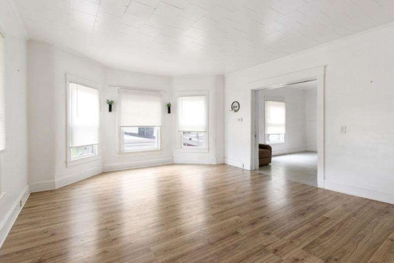 210 North Main Street Tampico, IL 61283 - Photo 4 of 10 a view of an empty room with window and wooden floor