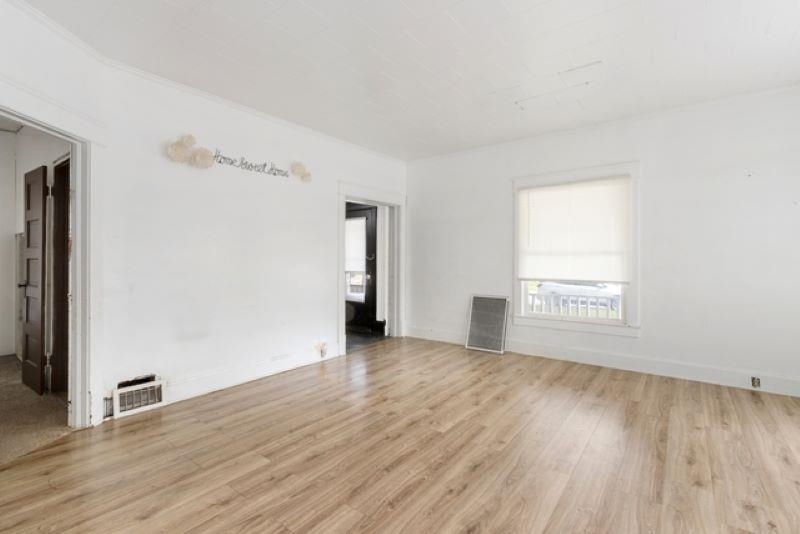 210 North Main Street Tampico, IL 61283 - Photo 5 of 10 an empty room with wooden floor and windows