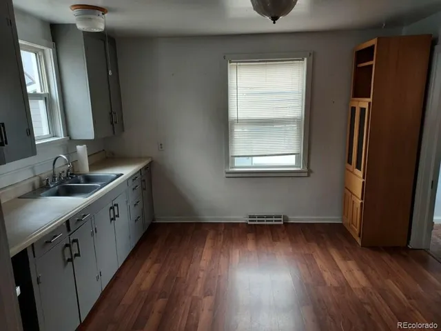 a kitchen with a wooden floor and a window