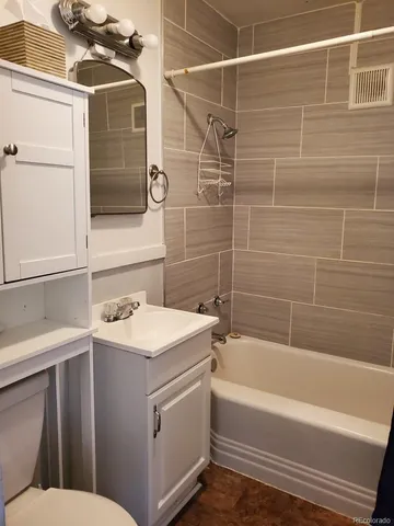a bathroom with a sink toilet vanity and bathtub