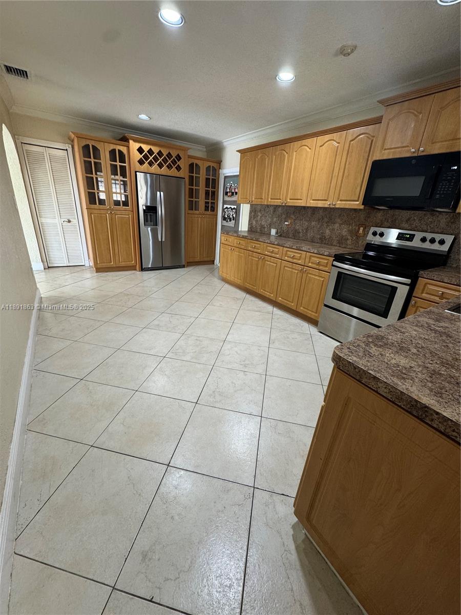 110 West 44th Street, Unit 110 Hialeah, FL 33012 - Photo 10 of 10 a kitchen with granite countertop a refrigerator and a stove top oven