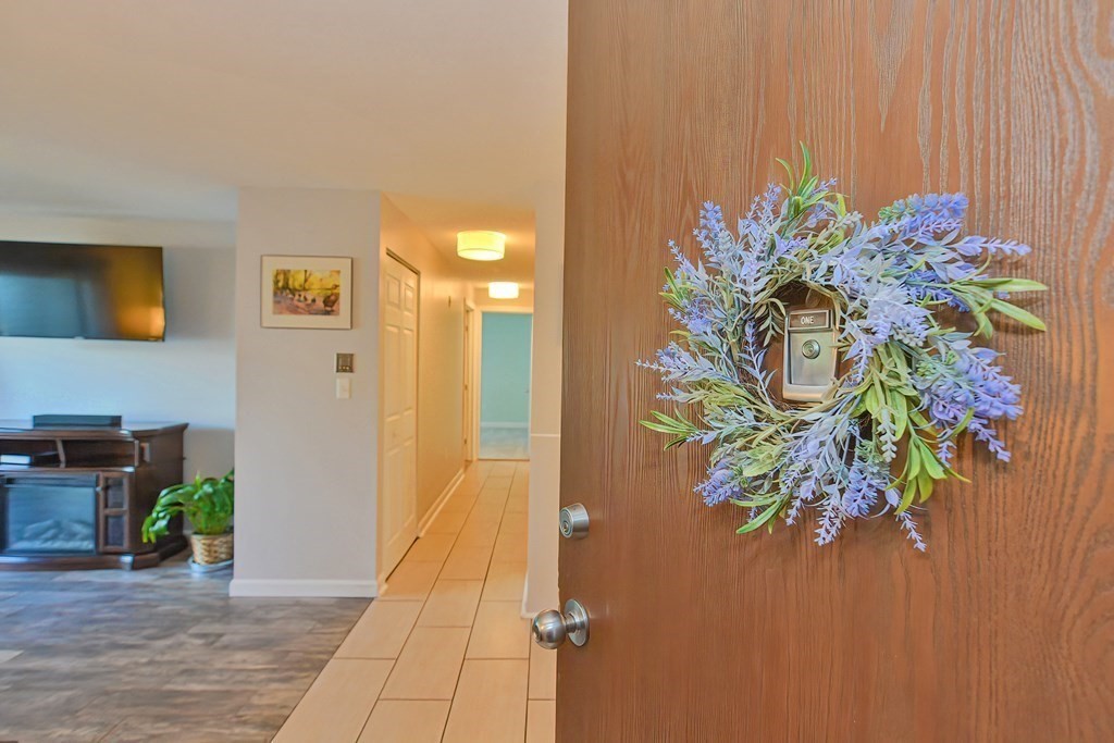 a view of a hallway with wooden floor and a potted plant