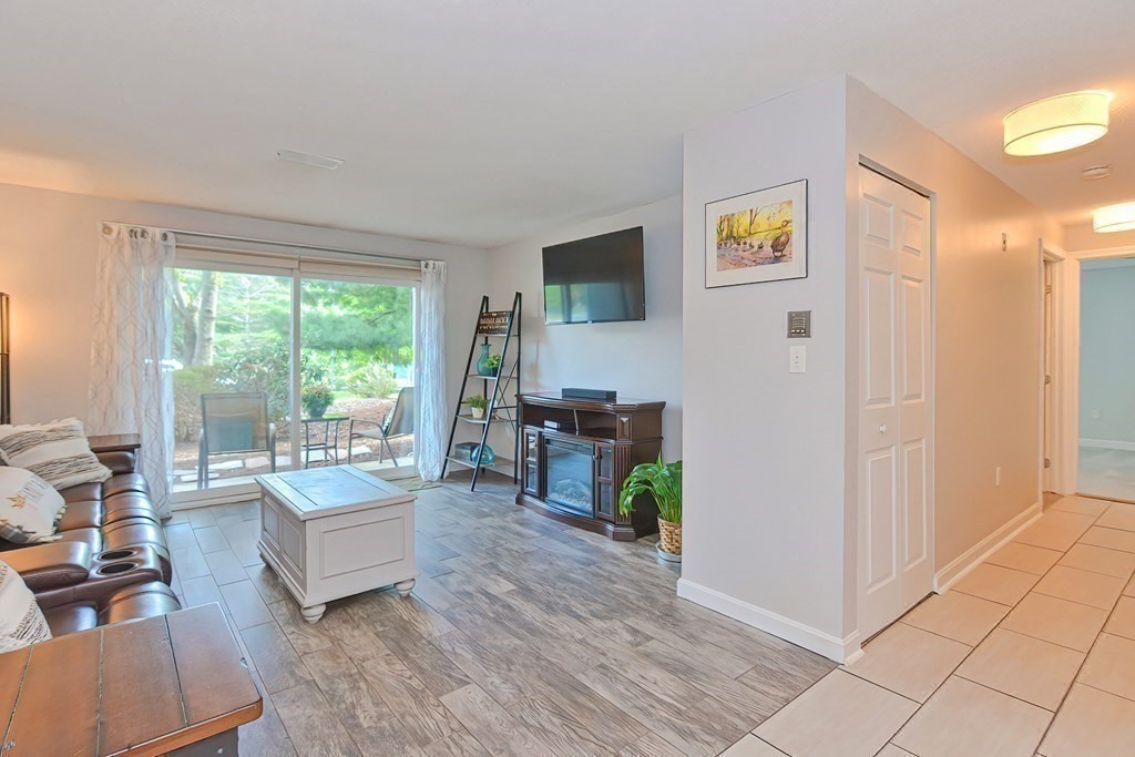 801 Franklin Crossing Road, Unit 801 Franklin, MA 02038 - Photo 13 of 38 a living room with furniture and a floor to ceiling window
