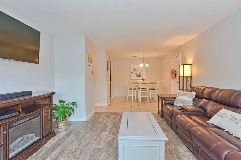 801 Franklin Crossing Road, Unit 801 Franklin, MA 02038 - Photo 16 of 38 a living room with furniture and a wooden floor