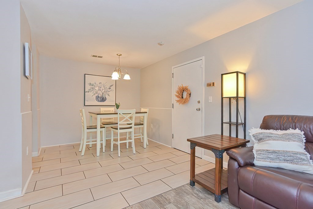 801 Franklin Crossing Road, Unit 801 Franklin, MA 02038 - Photo 17 of 38 a view of a dining room with furniture and chandelier
