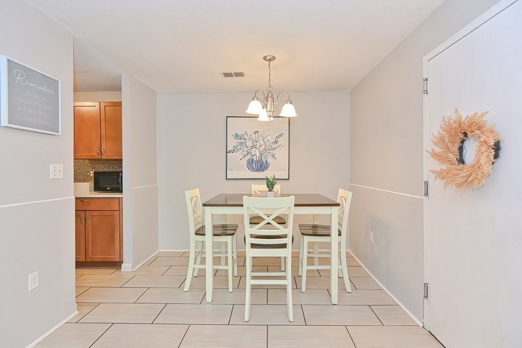 801 Franklin Crossing Road, Unit 801 Franklin, MA 02038 - Photo 3 of 38 a view of a dining room with furniture and chandelier