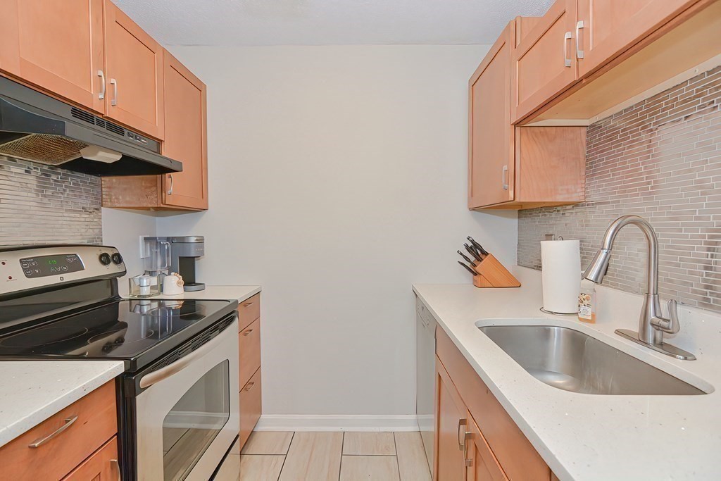 801 Franklin Crossing Road, Unit 801 Franklin, MA 02038 - Photo 6 of 38 a kitchen with stainless steel appliances granite countertop a sink stove and a refrigerator