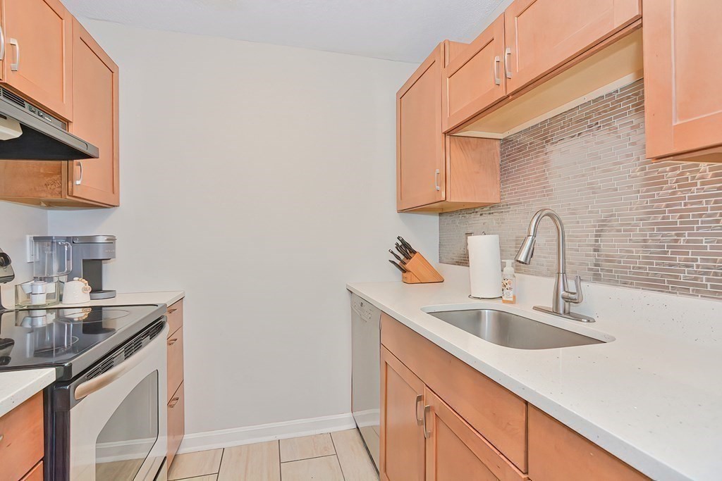 801 Franklin Crossing Road, Unit 801 Franklin, MA 02038 - Photo 7 of 38 a kitchen with sink a microwave and cabinets