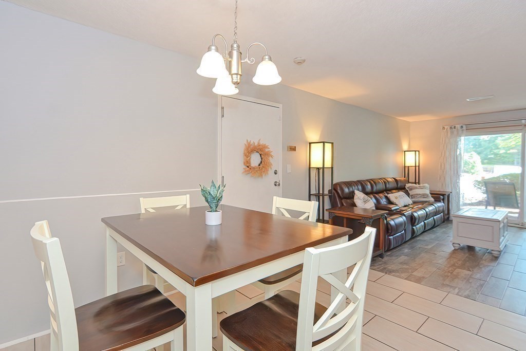 801 Franklin Crossing Road, Unit 801 Franklin, MA 02038 - Photo 10 of 38 a view of a dining room with furniture and wooden floor
