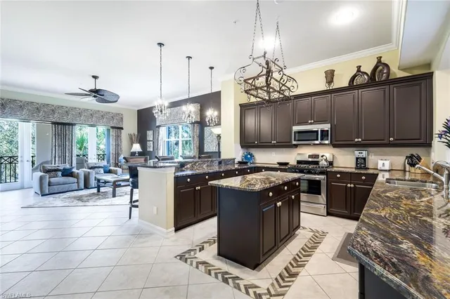 a kitchen with kitchen island granite countertop a sink counter top space appliances and cabinets