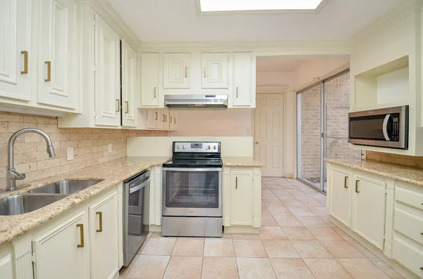 a kitchen with stainless steel appliances granite countertop a sink and a stove