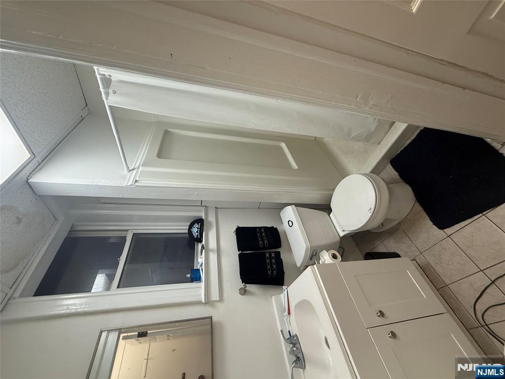 322 Anderson Avenue Fairview, NJ 07022 - Photo 4 of 13 a bathroom with a toilet sink and mirror