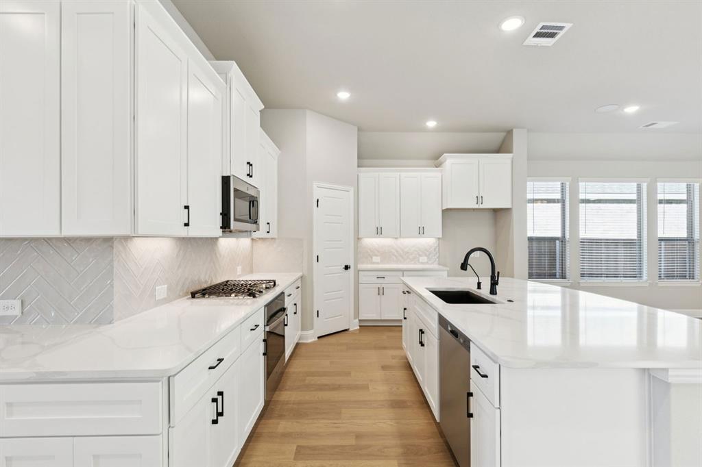 1366 Chisos Way Forney, TX 75126 - Photo 12 of 38 a kitchen with stainless steel appliances a sink a stove and a refrigerator