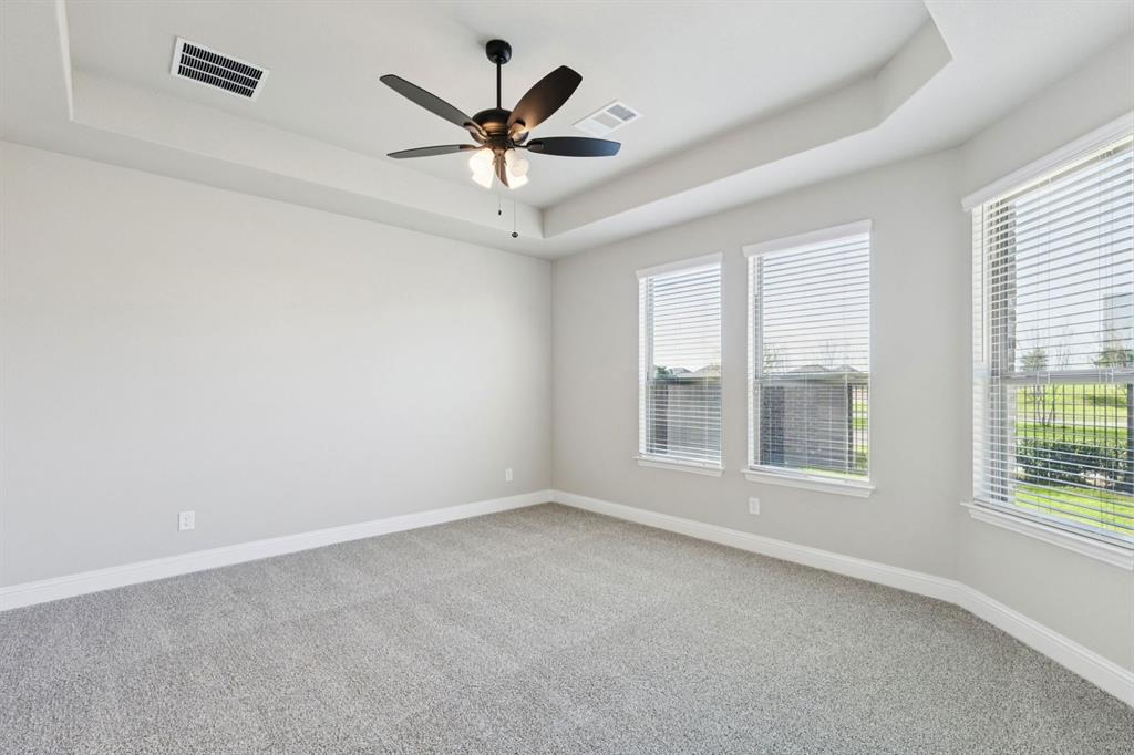 1366 Chisos Way Forney, TX 75126 - Photo 16 of 38 an empty room with a ceiling fan and windows