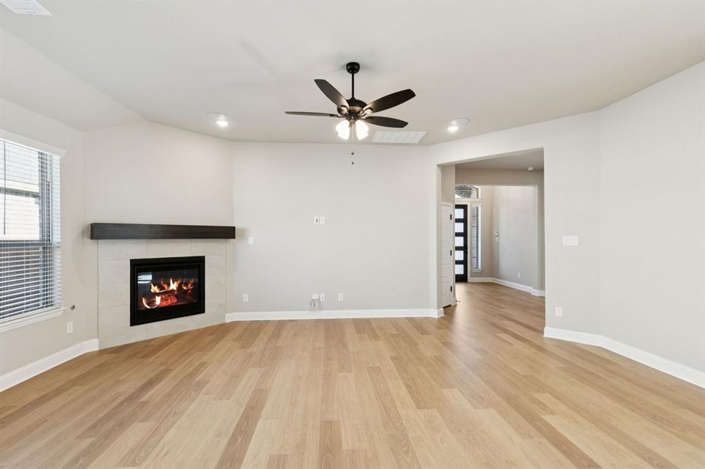 1366 Chisos Way Forney, TX 75126 - Photo 8 of 38 a view of an empty room with a fireplace and a window