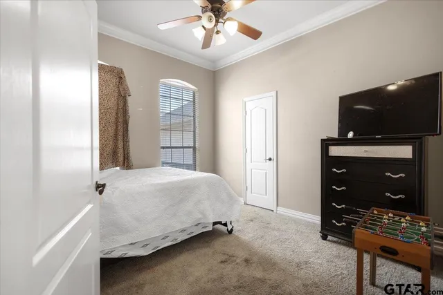 a bedroom with a bed and a flat tv screen on wall