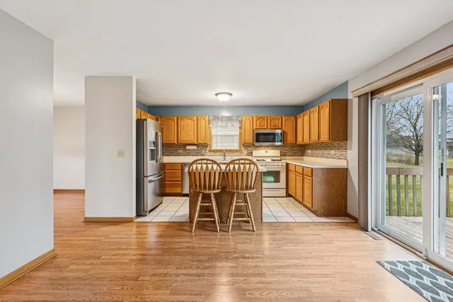 a kitchen with a table chairs refrigerator and cabinets