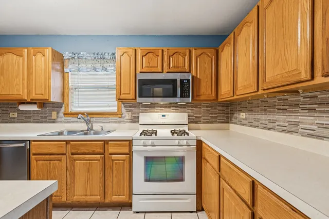 a kitchen with granite countertop wooden cabinets stainless steel appliances and a window