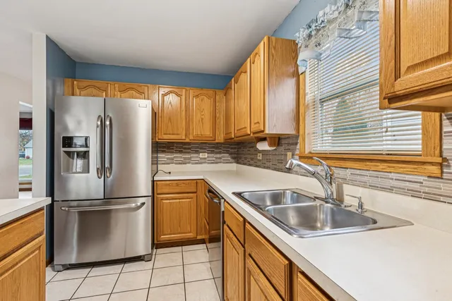 a kitchen with stainless steel appliances granite countertop a sink and a refrigerator