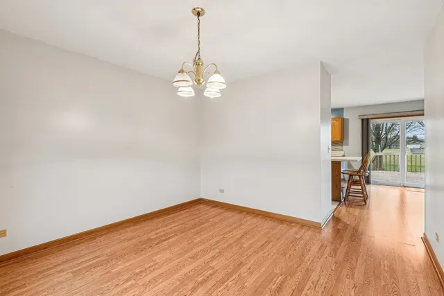 a view of empty room with wooden floor and window