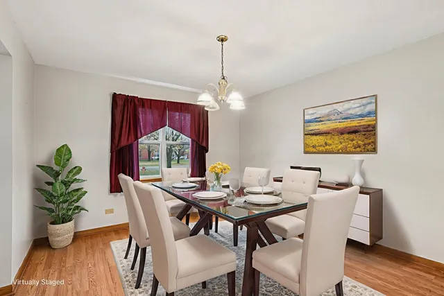 a dining room with furniture potted plants and wooden floor