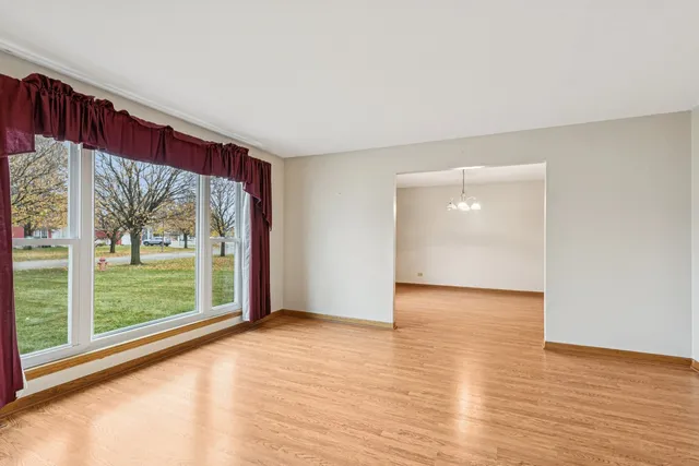 a view of a big room with wooden floor and windows