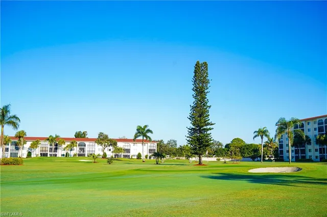 a front view of a house with a garden and trees