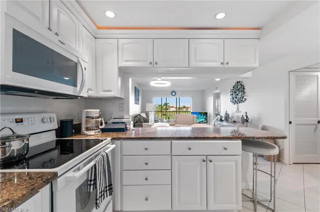a kitchen with granite countertop a sink stainless steel appliances and cabinets