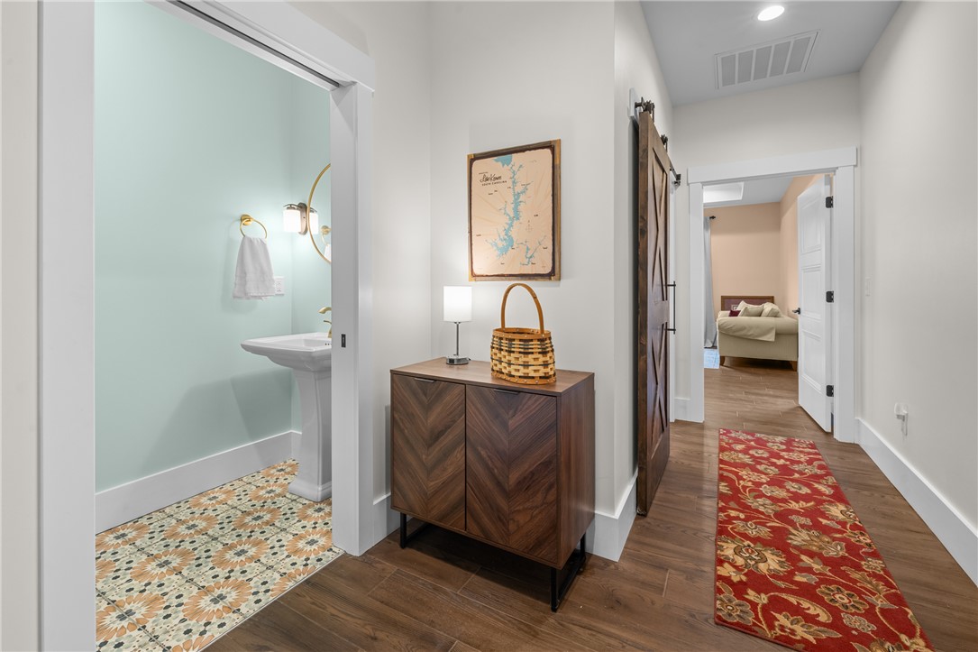 113 South Oak Pointe Drive Seneca, SC 29672 - Photo 18 of 50 This interior hallway features warm flooring, leading to a vibrant bathroom and a comfortable living area.