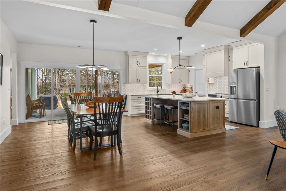 113 South Oak Pointe Drive Seneca, SC 29672 - Photo 10 of 50 This luminous open-concept space features warm wood flooring and exposed ceiling beams, seamlessly connecting living areas.